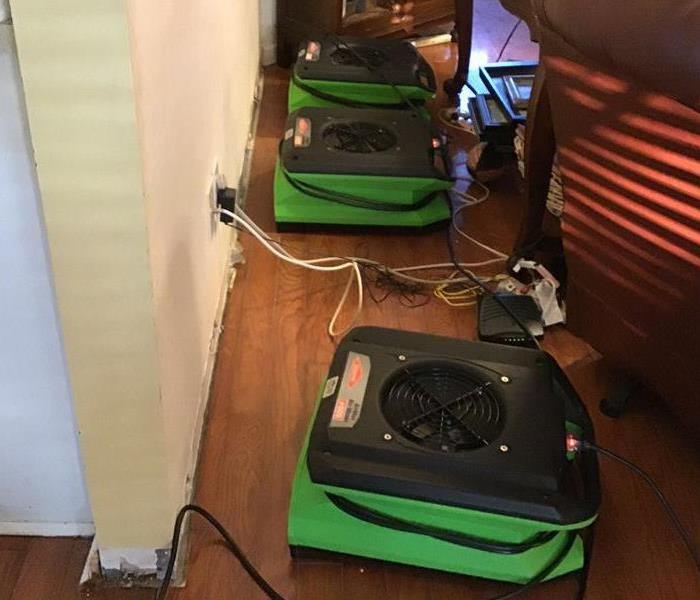 Three pieces of SERVPRO equipment on the floor in a living room 