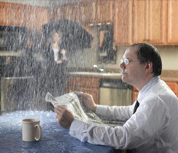 Man reading newspaper while water leaks